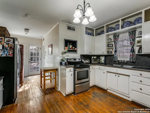 a kitchen with stainless steel appliances granite countertop a stove and cabinets