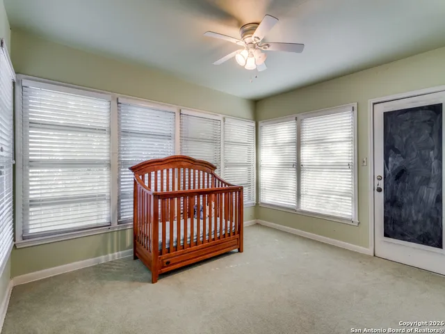 an empty room with windows and fan