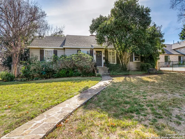 a front view of a house with a yard and trees