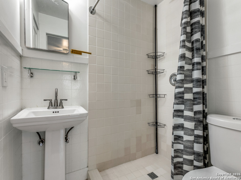 316 Elizabeth Road Terrell Hills, TX 78209 - Photo 22 of 25 a bathroom with a sink a mirror a toilet and shower