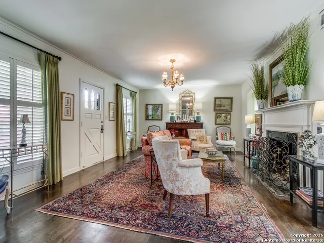 a living room with furniture a fireplace and a chandelier