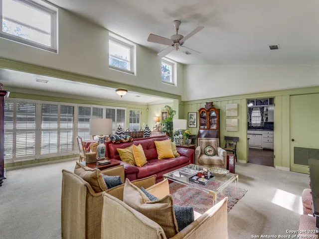 a living room with furniture a ceiling fan and a window
