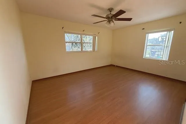 an empty room with a window and a ceiling fan