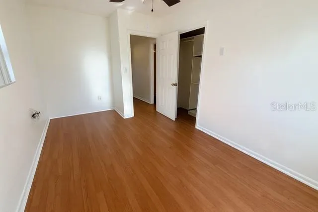 an empty room with wooden floor and closet