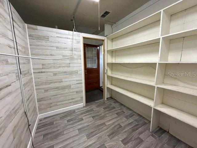 a room with walk in closet and wooden floor