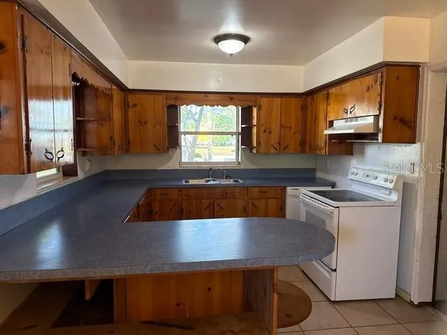 a kitchen with a sink a stove and cabinets