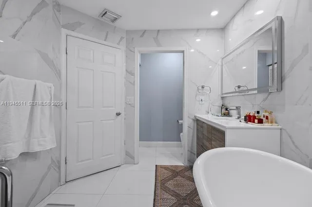 a bathroom with a bathtub sink vanity and toilet