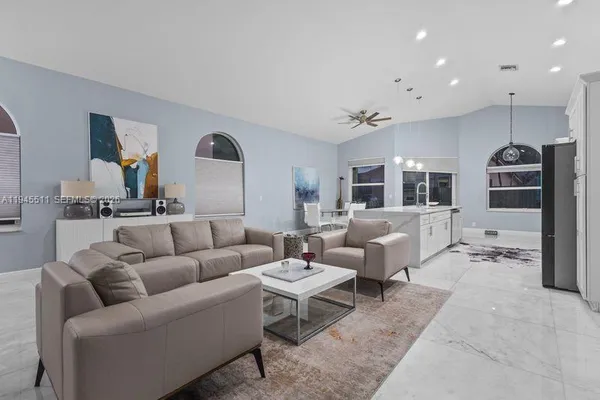 a living room with furniture and view of kitchen