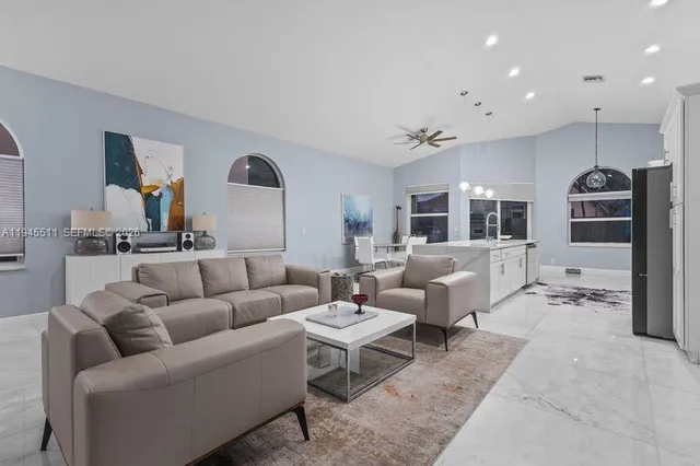 a living room with furniture and view of kitchen