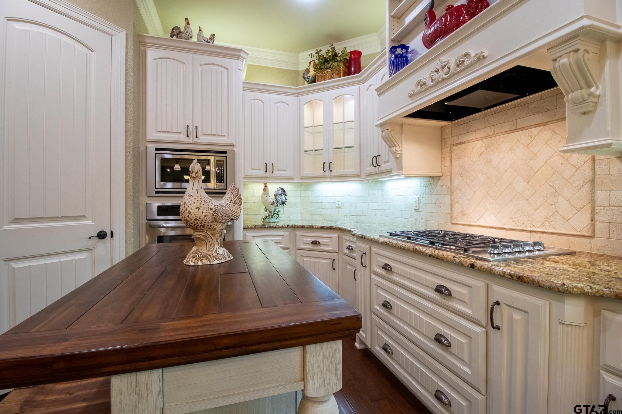 7315 Princedale Tyler, TX 75703 - Photo 16 of 25 a kitchen with kitchen island white cabinets and appliances