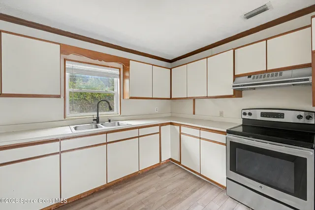 a kitchen with a sink stove and cabinets
