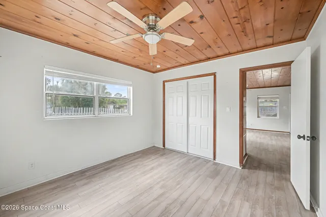a view of empty room with wooden floor