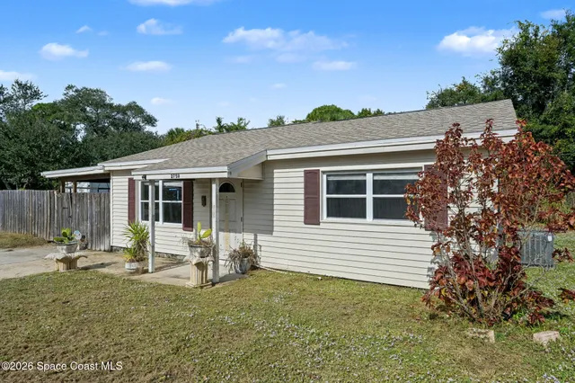 a view of a house with backyard and sitting area