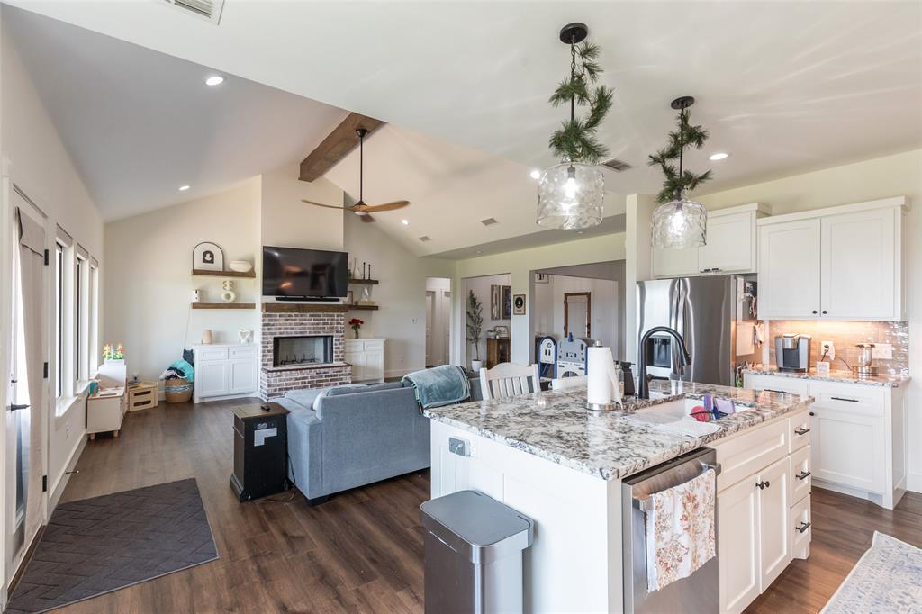 143 Purcell Lane Tuscola, TX 79562 - Photo 12 of 35 a kitchen with kitchen island granite countertop a large center island a sink dishwasher a dining table and chairs with wooden floor