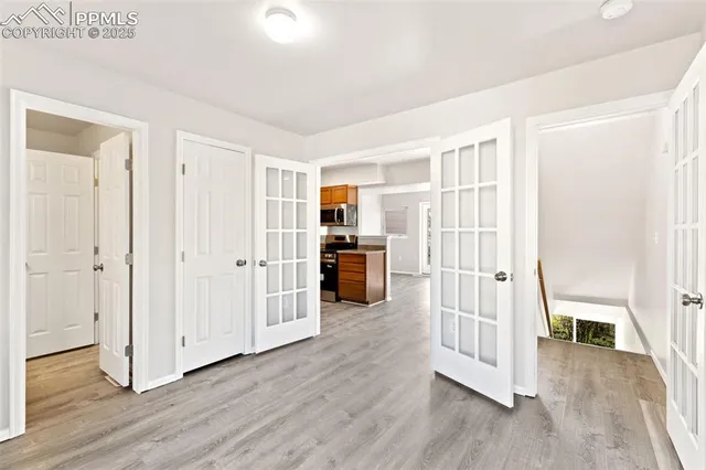 an empty room with wooden floor and windows