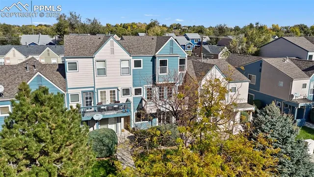 an aerial view of residential houses with outdoor space and trees
