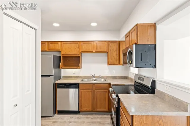 a kitchen with stainless steel appliances granite countertop a refrigerator and a sink