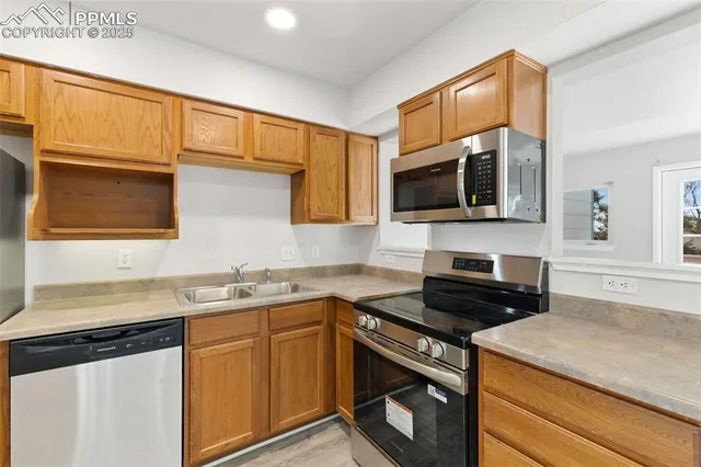 a kitchen with stainless steel appliances granite countertop a stove a sink and a microwave