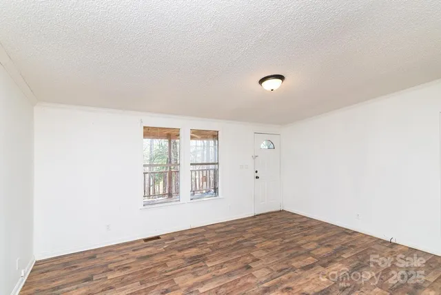 a kitchen with a refrigerator a stove a sink and white cabinets with wooden floor