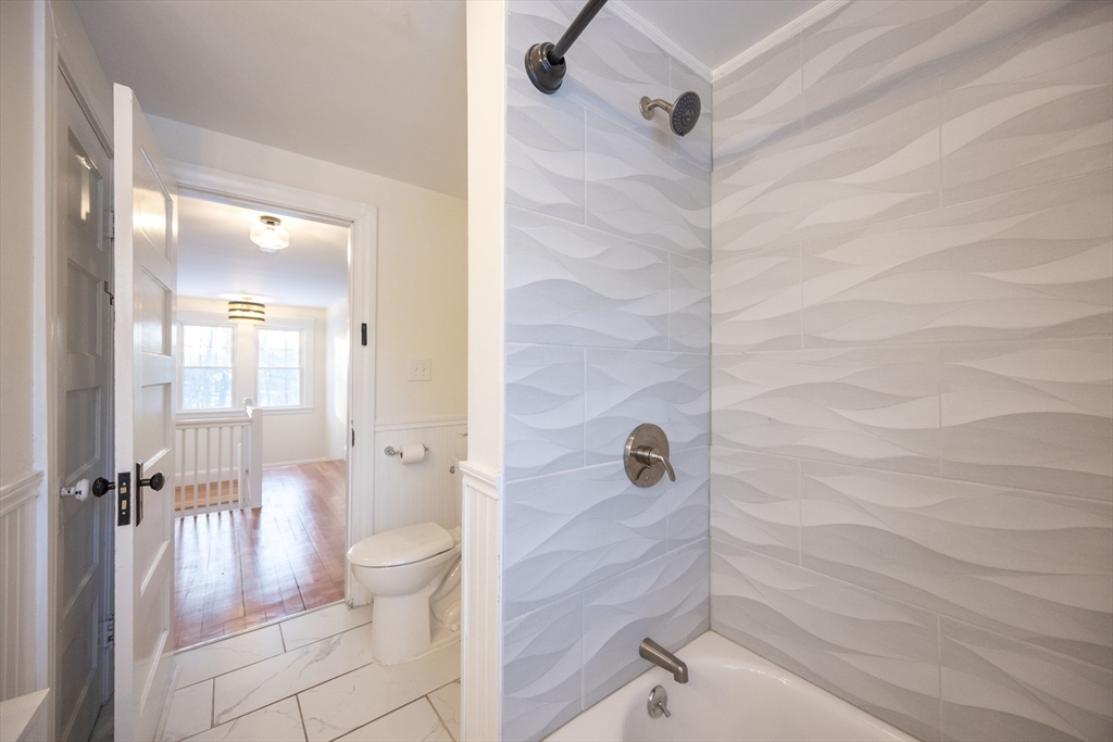 42 York Street Andover, MA 01810 - Photo 20 of 35 a bathroom with a granite countertop bathtub shower and toilet