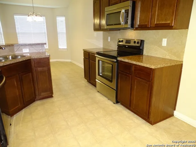 a kitchen with stainless steel appliances a stove a sink a microwave and cabinets
