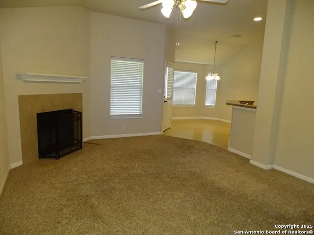 a view of an empty room with a fireplace and a window