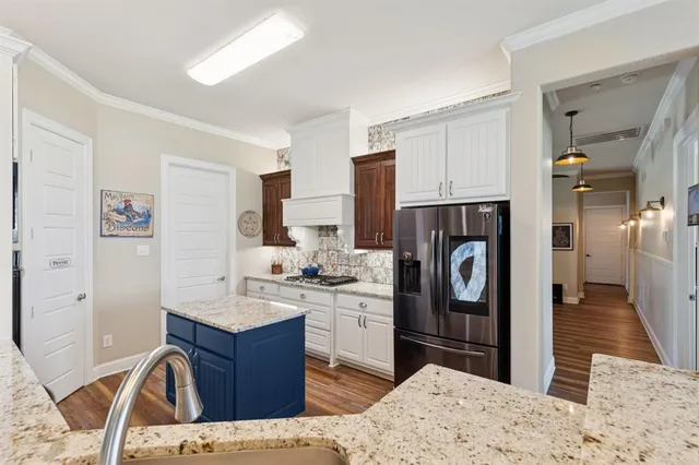 a kitchen with stainless steel appliances kitchen island sink stove refrigerator and cabinets