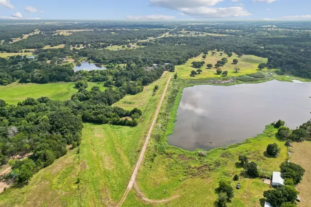 an aerial view of a house with a garden and mountains in the background