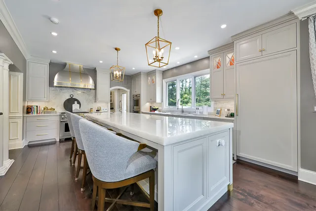 a large white kitchen with a large window a sink and stainless steel appliances