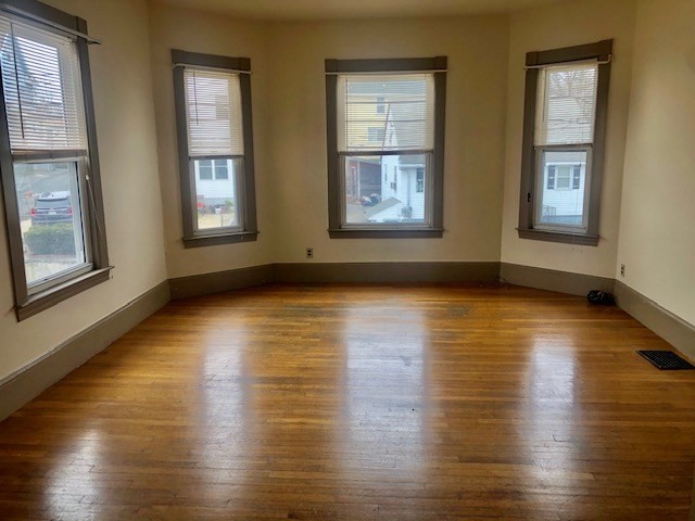 233 Washington Street, Unit 2 Malden, MA 02148 - Photo 2 of 14 a view of an empty room with wooden floor and windows