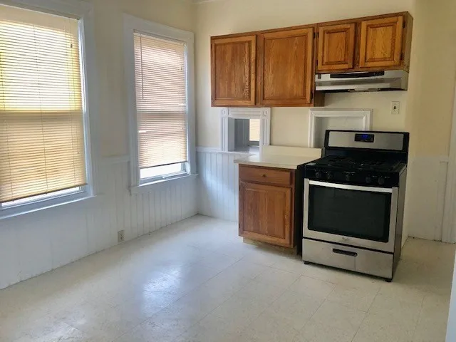 a kitchen with granite countertop white cabinets and stainless steel appliances