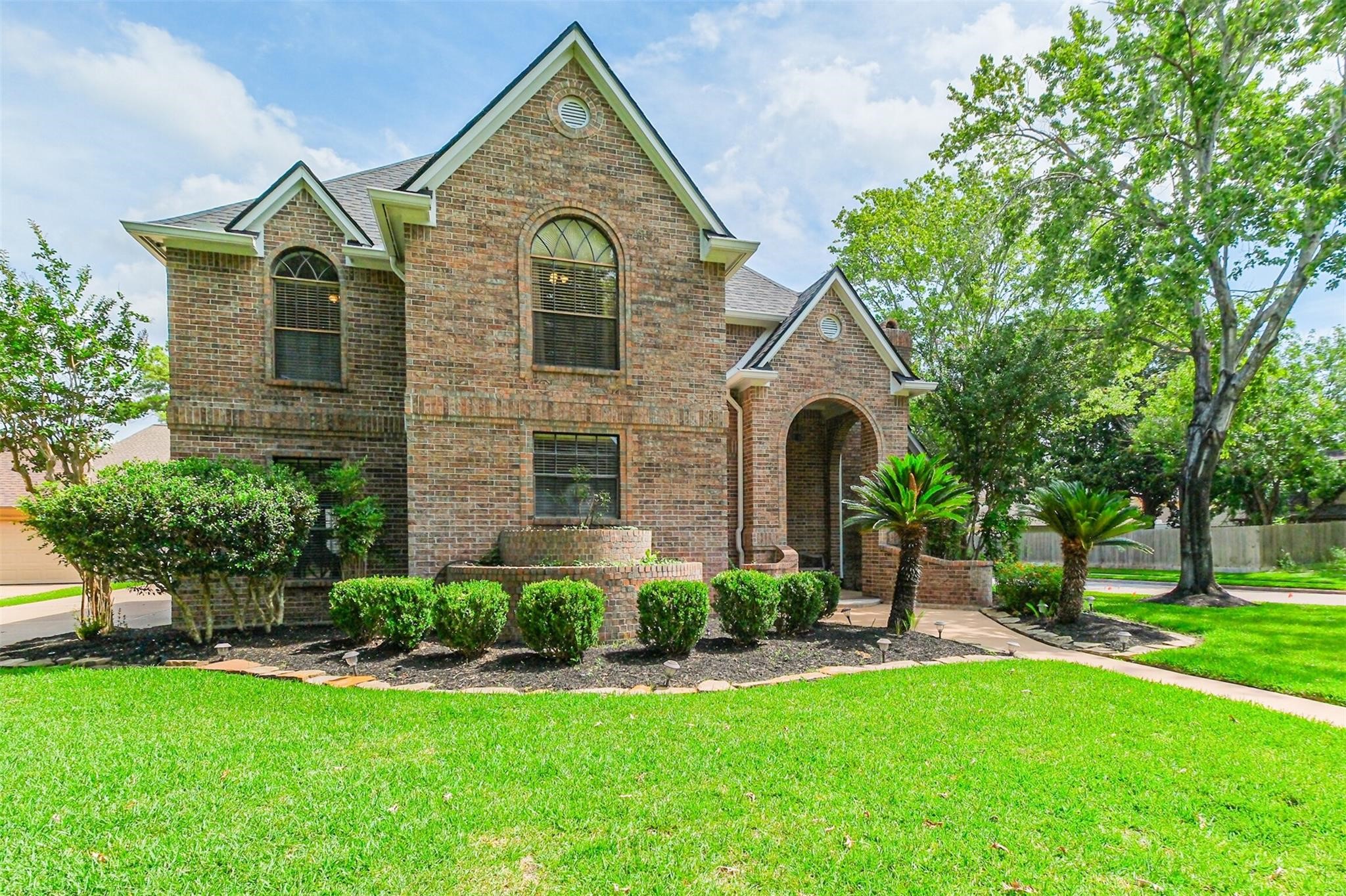 a front view of a house with a garden