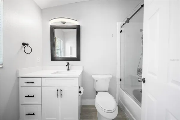 a bathroom with a toilet sink vanity and mirror