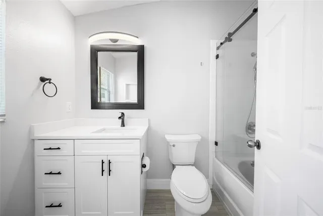 a bathroom with a toilet sink vanity and mirror