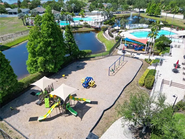 an aerial view of a swimming pool with a yard and seating area