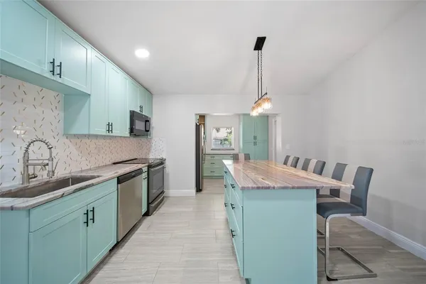 a kitchen with granite countertop cabinets a sink and appliances