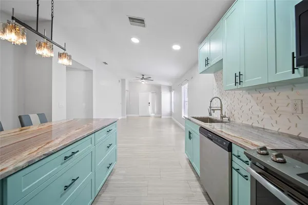 a kitchen with granite countertop a sink and a stove