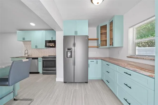 a kitchen with granite countertop a refrigerator and a stove top oven