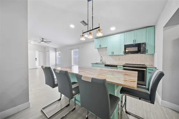 a kitchen with a table chairs refrigerator and microwave