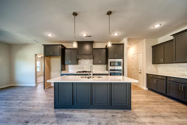 a view of a kitchen with a sink and a stove top oven