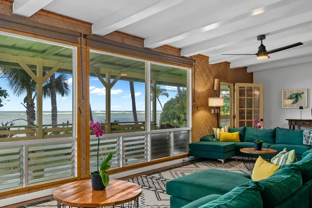 a living room with patio furniture and a potted plant