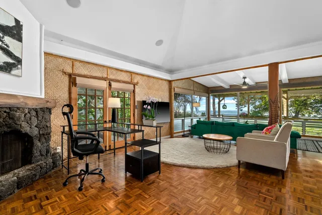 a living room with fireplace furniture and floor to ceiling windows