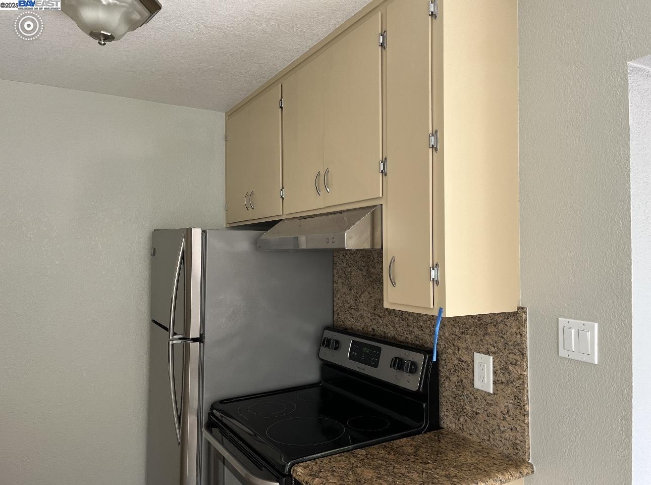 117 Day Street, Unit 204 San Francisco, CA 94131 - Photo 6 of 20 a kitchen with a refrigerator and cabinets