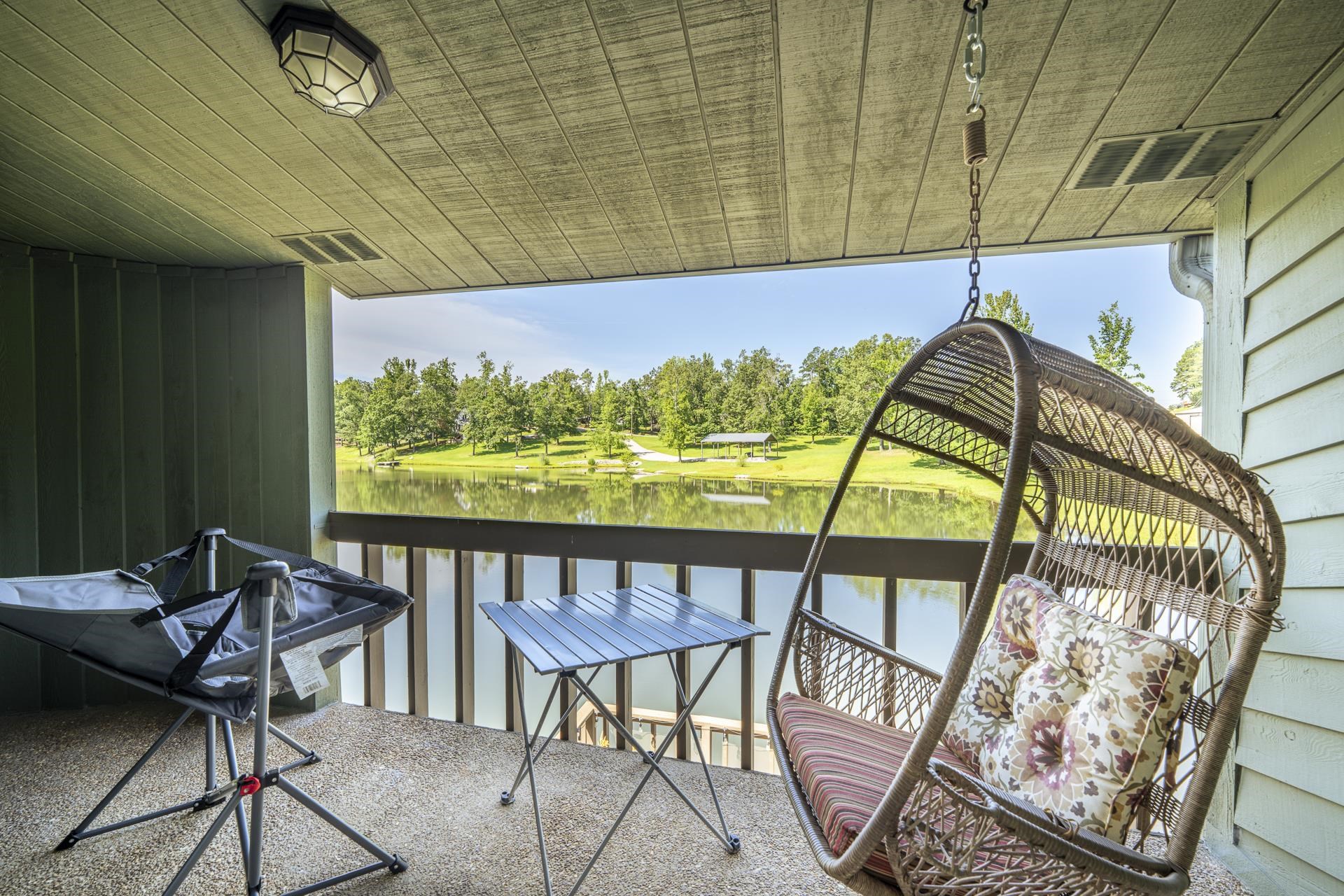 74 Driftwood Road Counce, TN 38326 - Photo 29 of 40 Covered outdoor balcony with a tranquil water feature backdrop, featuring a slatted ceiling, exterior wall light, and wood-finish railing. Off Primary Bedroom