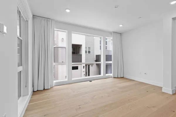 a view of an empty room with wooden floor and entryway