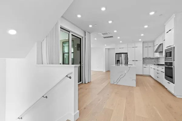 a living room with stainless steel appliances kitchen island furniture and a view of kitchen
