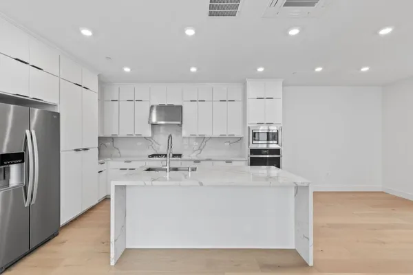 a kitchen with stainless steel appliances granite countertop a sink stove and refrigerator