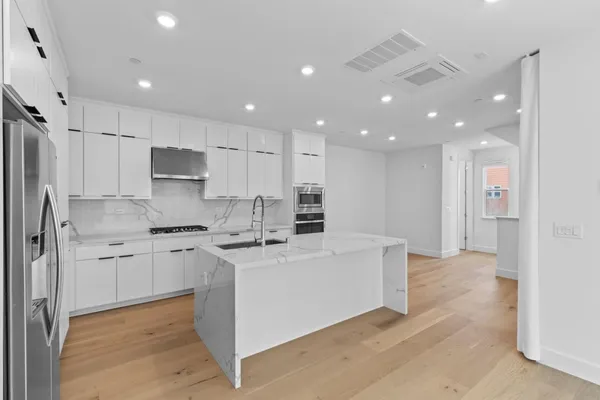 a large kitchen with stainless steel appliances kitchen island a stove a refrigerator a sink and a stove