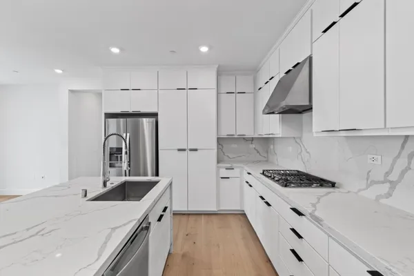 a kitchen with stainless steel appliances kitchen island a sink stove and refrigerator