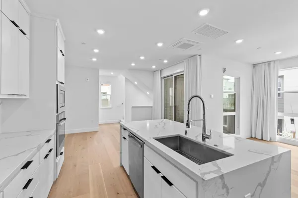 a kitchen with granite countertop a sink stove and refrigerator